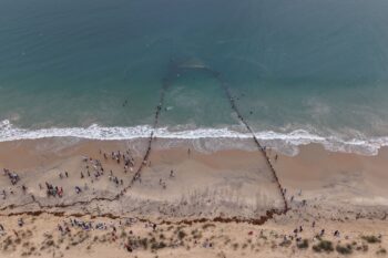 A shore seine net is hauled ashore at Valinokam, Tamil Nadu, while people gather along the beach to watch. Image by Vinod Kumar.